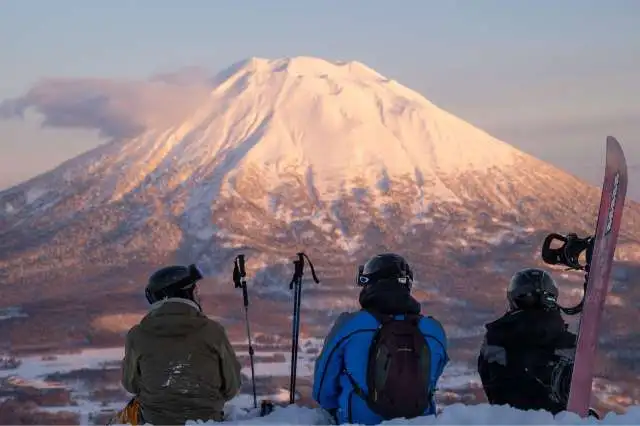 Skiers snowboarders hirafu slopes mount yotei sunset